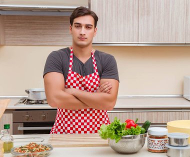 Erkek aşçı mutfakta yemek hazırlıyor.