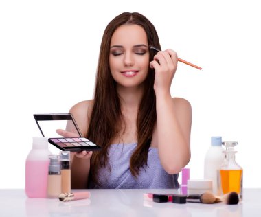 Beyazlar içinde makyaj yapan kadın.