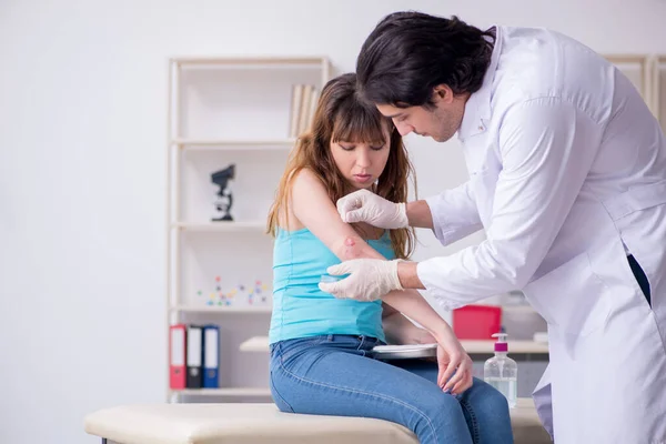 Joven brazo lesionado mujer visitando joven médico traumatólogo — Foto de Stock