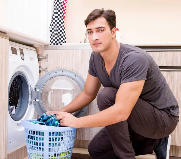 Jovem marido fazendo lavanderia em casa — Fotografia de Stock