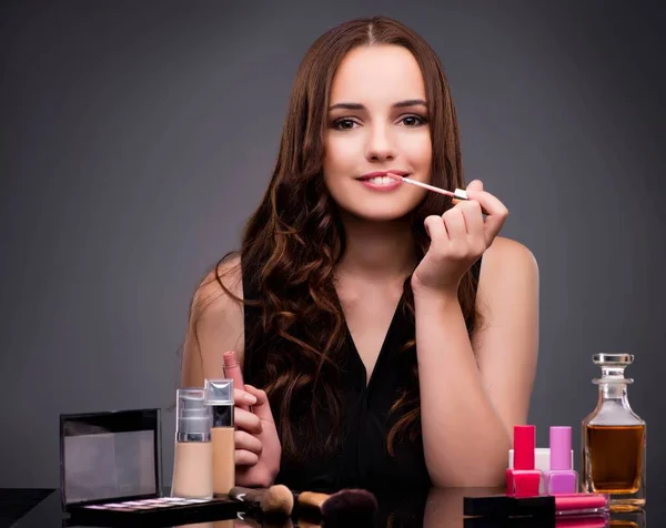 Žena, která dělá make-up na tmavém pozadí — Stock fotografie