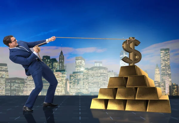 Бизнесмен тянет доллары и золотые слитки — стоковое фото