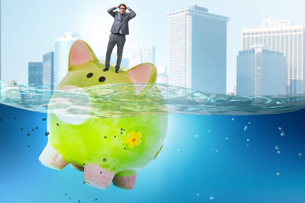 Бизнесмен в долговой концепции с копилкой