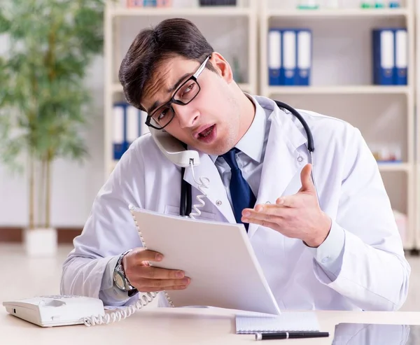 Junger Arzt sitzt im Büro — Stockfoto