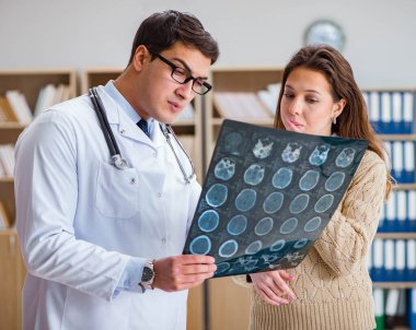 Genç doktor bilgisayardaki röntgen görüntülerine bakıyor.