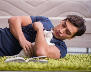 Yakışıklı delikanlı beyaz yavru kedi ile oynarken