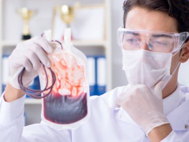 Hastane kliniğinde kan örnekleriyle çalışan bir doktor.