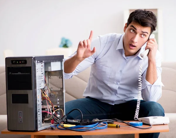 Zły klient próbuje naprawić komputer z pomocą telefonu — Zdjęcie stockowe
