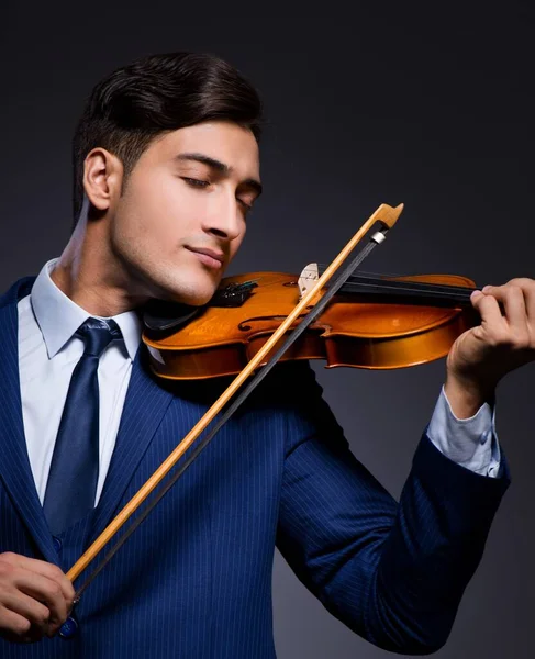 Jovem tocando violino no quarto escuro — Fotografia de Stock