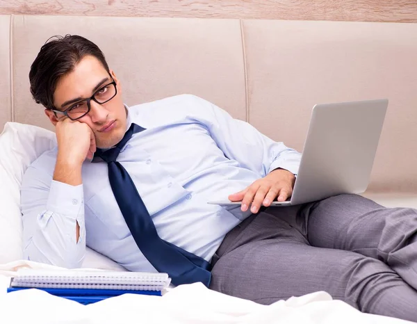 Geschäftsmann arbeitet zu Hause im Bett — Stockfoto