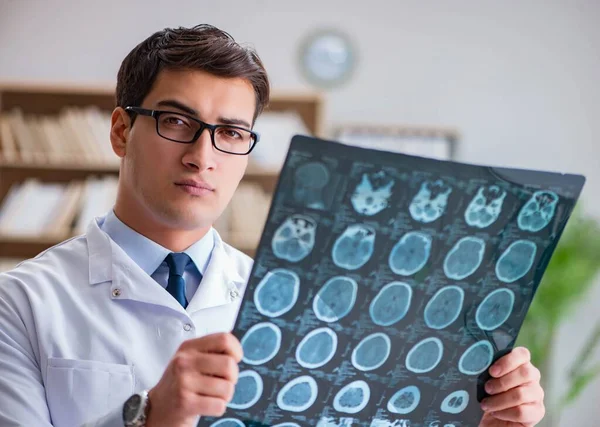 年轻的医生看着 x 射线计算机断层扫描图像 — 图库照片
