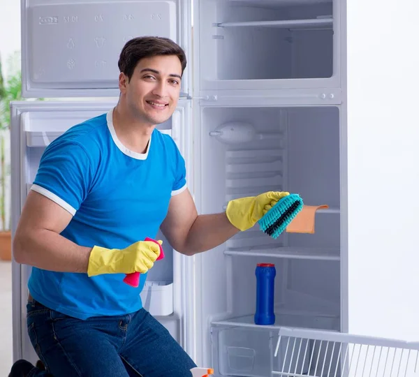 Mann putzt Kühlschrank im Hygienekonzept — Stockfoto