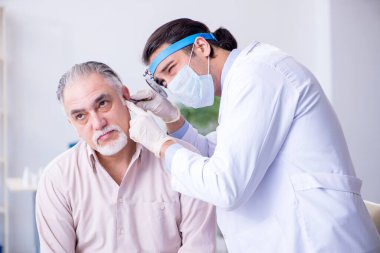 Erkek hasta doktor otolaryngologu ziyaret ediyor.