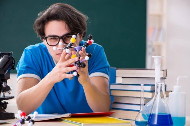 Sınıftaki genç erkek öğrenci.