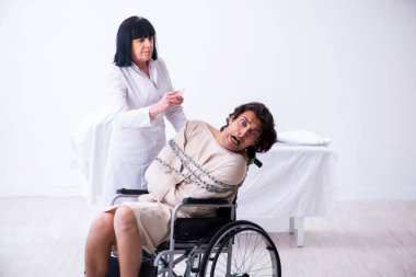 Yaşlı kadın psikiyatrist genç erkek hastayı ziyaret ediyor