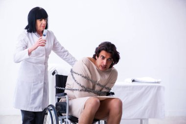 Yaşlı kadın psikiyatrist genç erkek hastayı ziyaret ediyor