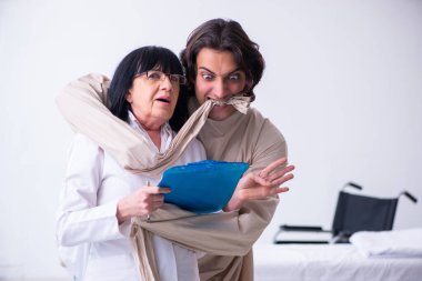 Yaşlı kadın psikiyatrist genç erkek hastayı ziyaret ediyor