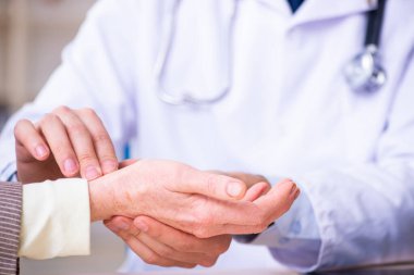 Genç doktor yaşlı yaşlı kadını muayene ediyor.