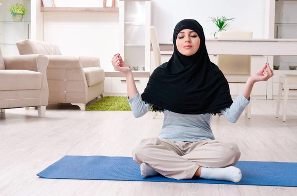 Junge Frau im Hidschab macht Übungen zu Hause — Stockfoto