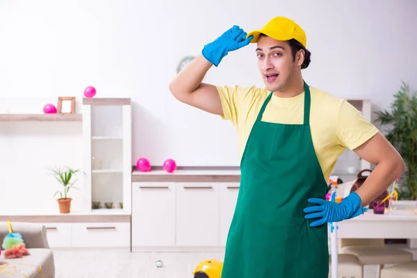 Ung manlig entreprenör som utför hushållsarbete efter fest — Stockfoto
