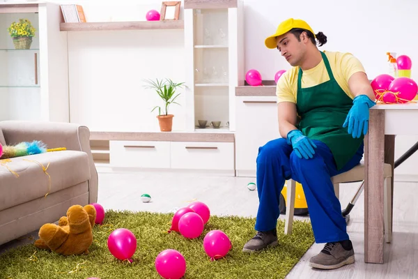 Junge männliche Bauunternehmer erledigen Hausarbeit nach Party — Stockfoto