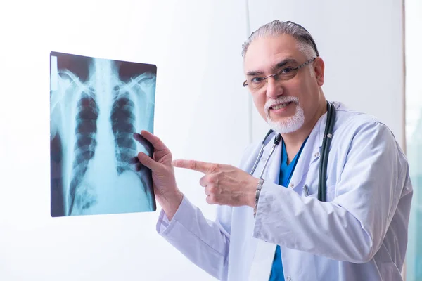 Old male doctor working in the clinic