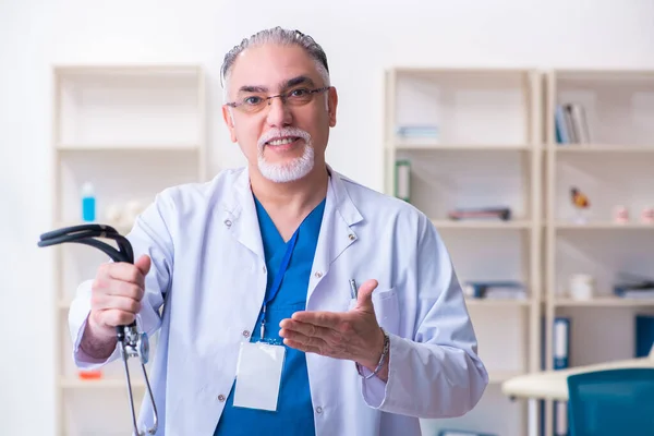 Klinikte çalışan yaşlı erkek doktor. — Stok fotoğraf