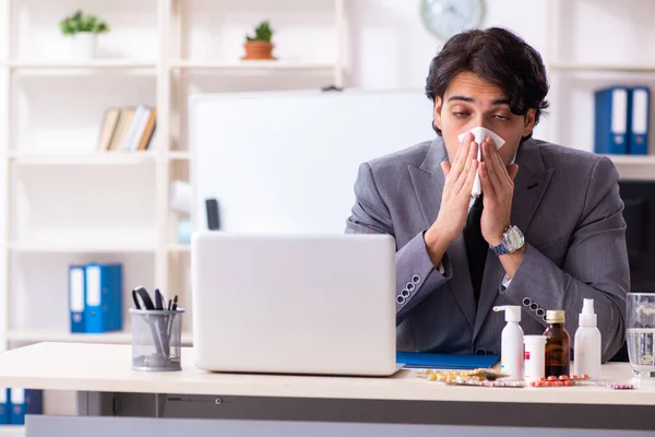Mężczyzna z grypą pracujący w biurze — Zdjęcie stockowe