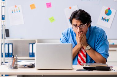 Ofiste çalışan genç bir erkek finans müdürü.