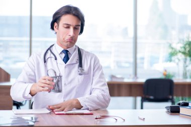 Klinikte çalışan yakışıklı genç bir doktor.