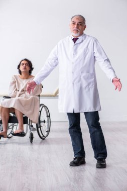 Yaşlı erkek psikiyatrist ve tekerlekli sandalyedeki hasta.