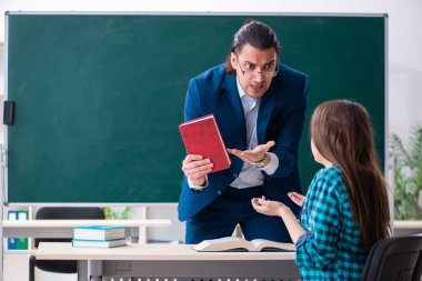 Sınıftaki genç, yakışıklı öğretmen ve bayan öğrenci.