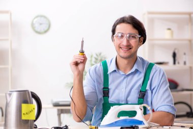 Delikanlı servis merkezinde demir onarıyor.