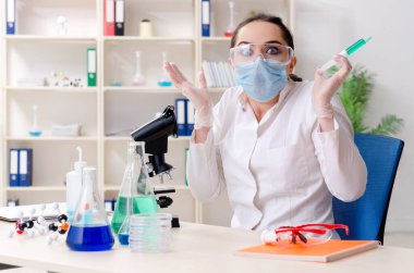 Laboratuvarda çalışan genç bir kadın kimyager.