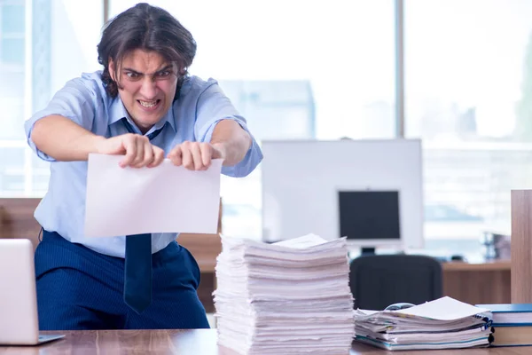 Jovem funcionário infeliz com excesso de trabalho — Fotografia de Stock