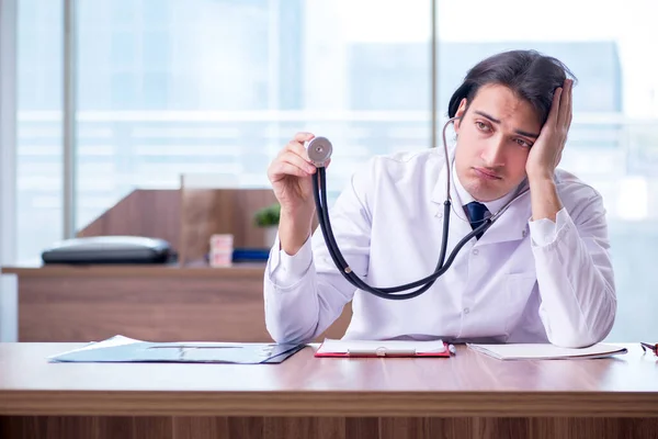 Joven médico guapo que trabaja en la clínica — Foto de Stock