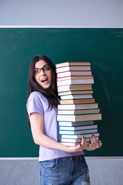 Jovem estudante professora na frente do quadro verde — Fotografia de Stock