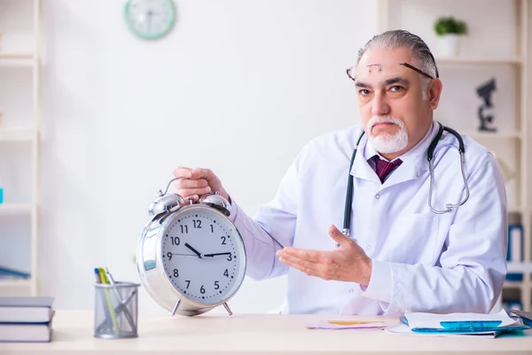 Old male doctor working in the clinic — Stock Photo, Image