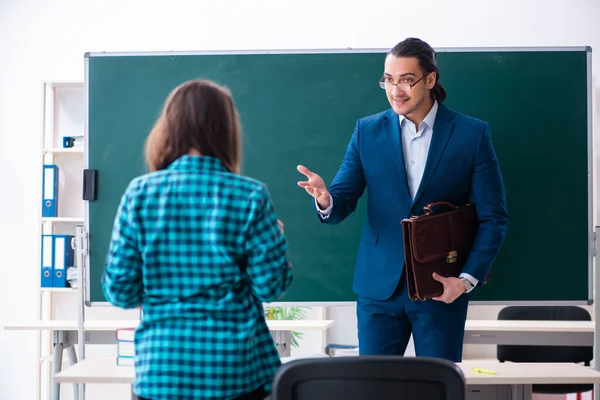 Jonge knappe leraar en vrouwelijke student in de klas — Stockfoto