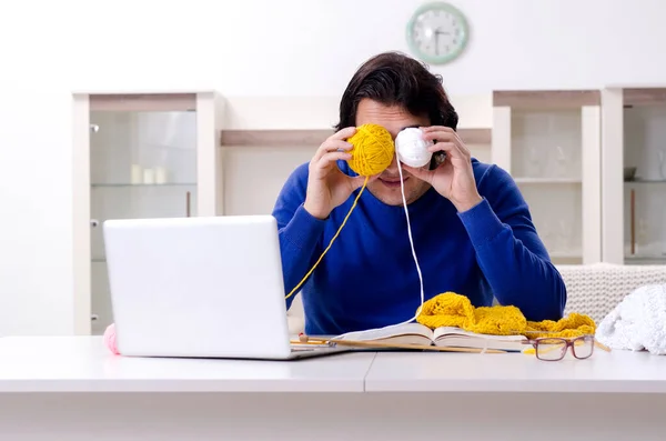 Jonge goed uitziende man breit thuis — Stockfoto