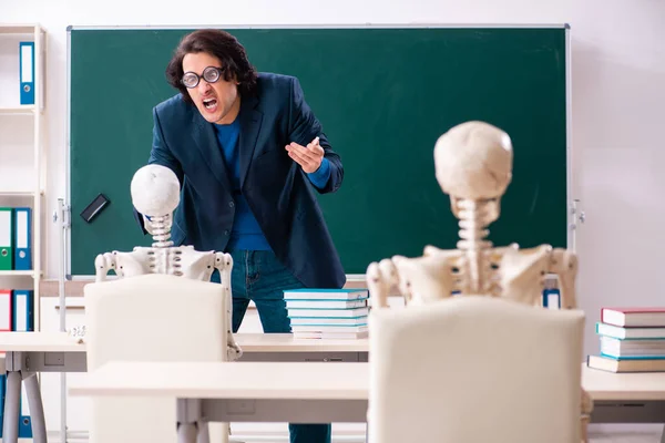 Manlig lärare och skelettelev i klassrummet — Stockfoto