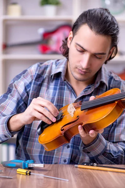 Joven reparador guapo reparando violín — Foto de Stock