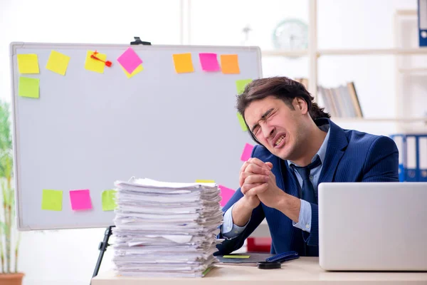 Young male employee unhappy with excessive work — Stock Photo, Image