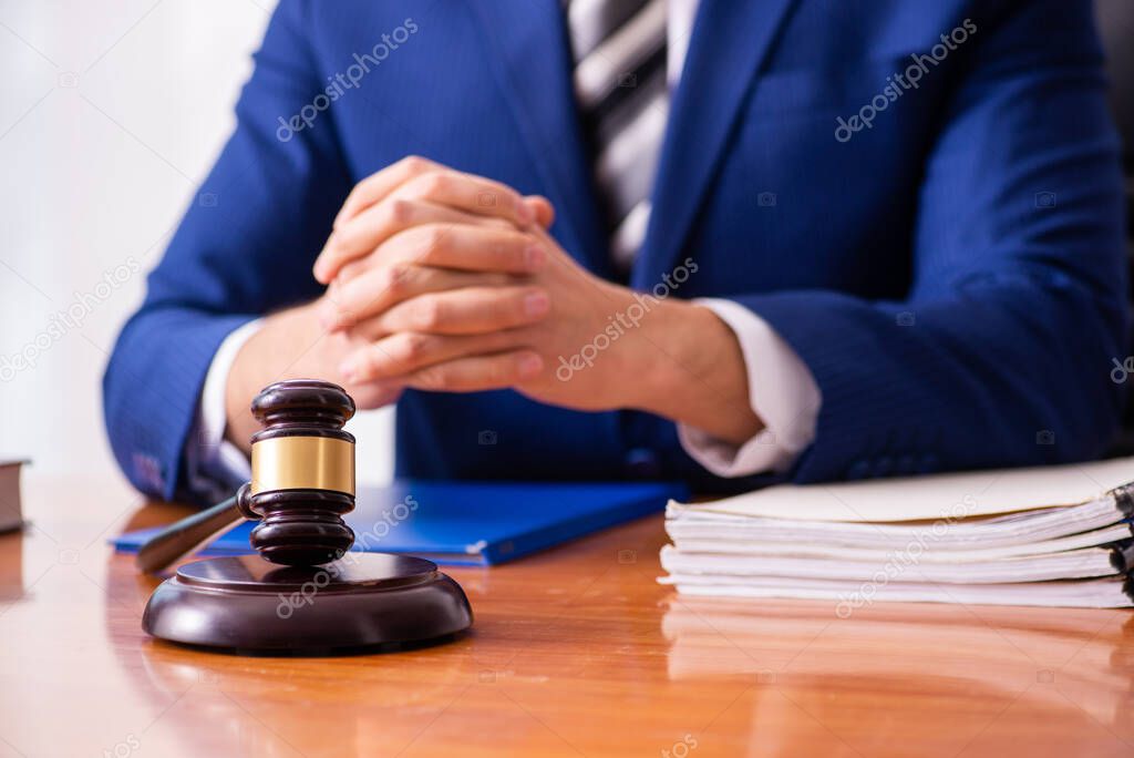 Young male judge sitting in courtroom