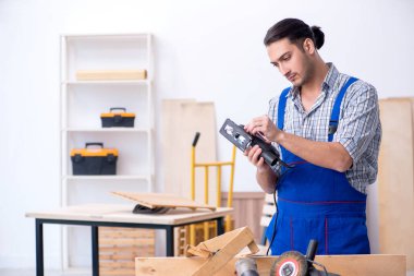 Genç erkek marangoz içeride çalışıyor.