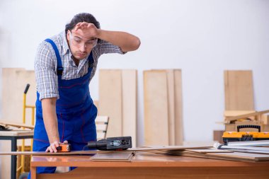 Genç erkek marangoz içeride çalışıyor.