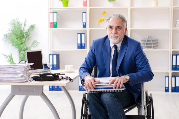 Älterer Mitarbeiter im Rollstuhl arbeitet im Büro — Stockfoto