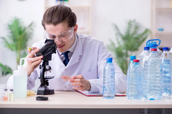 Молодой химик-мужчина экспериментирует в лаборатории — стоковое фото