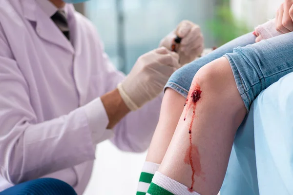 Benskadad ung kvinna besöker manlig läkare — Stockfoto