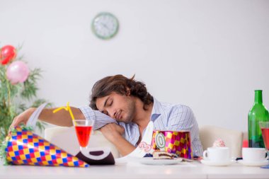 Genç adam doğum gününü evde kutluyor.